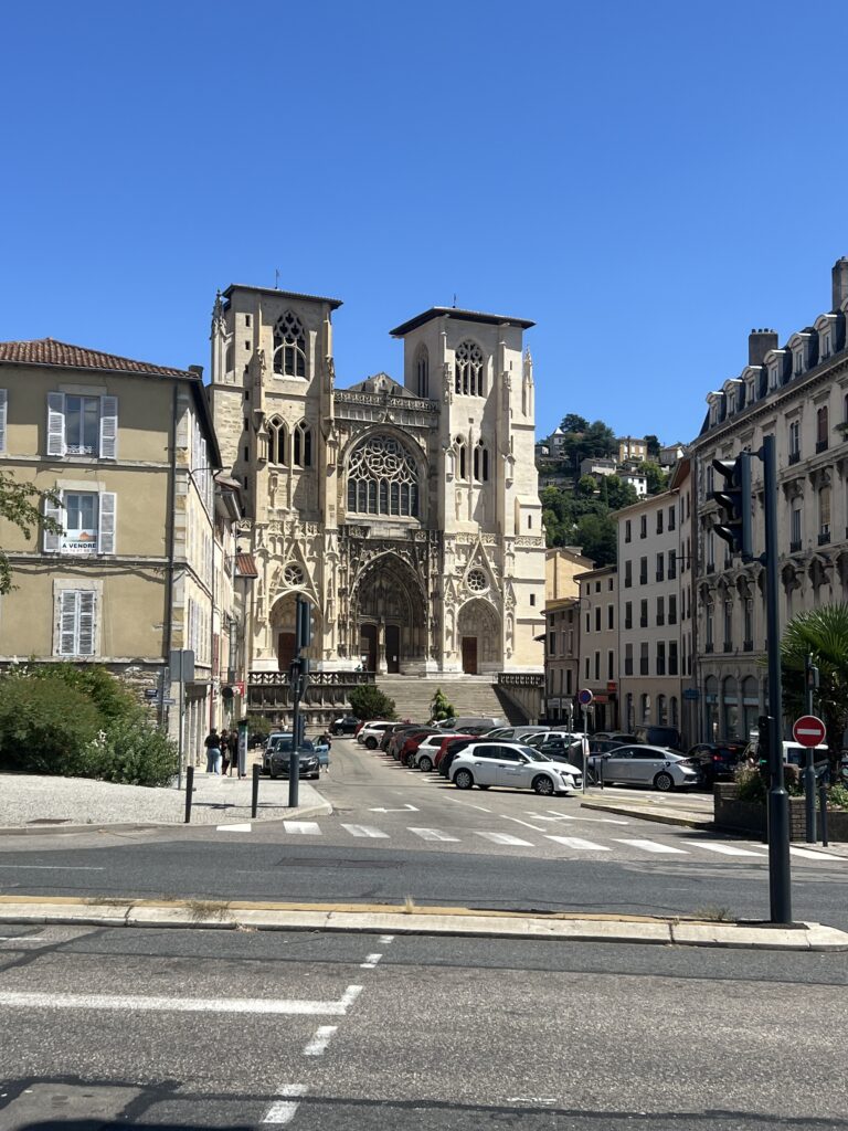 Fachada gótica da Catedral Saint-Maurice de Vienne, com suas torres imponentes e vitrais coloridos, símbolo da história medieval e patrimônio religioso da cidade.